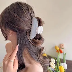 Close-up of a large pearlescent crescent hair claw clip for elegant French hairstyles