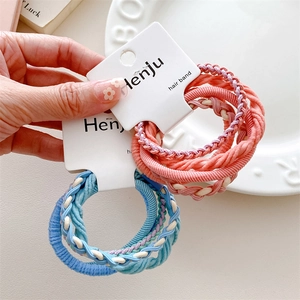 Detail of high-elastic braided hair ties in pink and blue tones with spiral textures