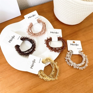 Set of 5 high-elastic ruffled chiffon hair scrunchies in warm earth tones on a white ceramic plate