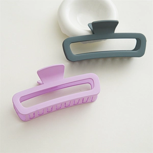 Detail of matte rectangular hair claws in lilac and greyish blue on white background