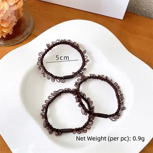 Three premium dark brown elastic hair ties with pleated mesh design on a white ceramic tray