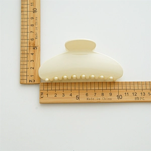 Large cream white hair claw clip with size measurement ruler showing 10.5cm length