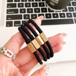 Lot de quatre chouchous noirs minimalistes avec détails en métal doré mat