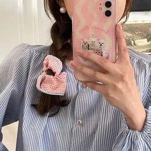 Detalle de coletero de cuadros rosas con borde azul sobre un peinado con trenzas