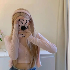 Détail d'un serre-tête large en similicuir rose clair porté avec un ensemble tricot