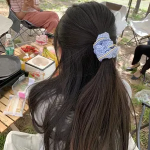 Coletero de cuadros vichy azules mostrado en un entorno exterior sobre una modelo