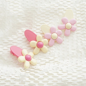 Detailed macro view of 4-piece set of pink and cream floral daisy hair clips