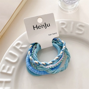 Detail showing high-elastic candy blue hair band set on decorative white ceramic plate