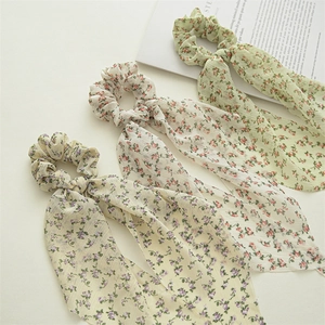 Detailed view of floral chiffon scrunchies with ribbons in green, white and yellow