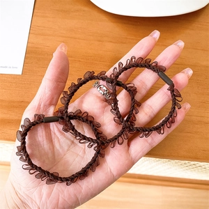 Close-up of three brown pleated mesh hair ties with elegant wavy lace texture and metallic clasp