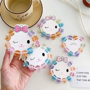 Cute transparent mini hair claws with flower and bear shapes on white card