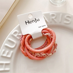 Detailed macro view of high-elastic pink hair bands in a white porcelain dish