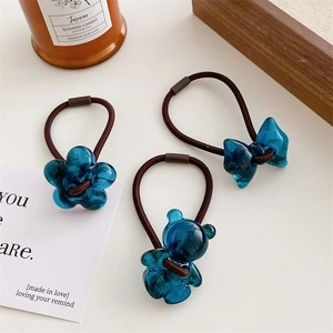 Detailed macro view of jelly blue flower and bear hair ties with high elastic brown bands