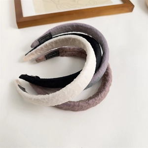 Close-up of pleated sponge headbands with handmade label and non-slip inner lining