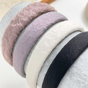 Detailed view of pleated fabric sponge headbands in four elegant assorted colors