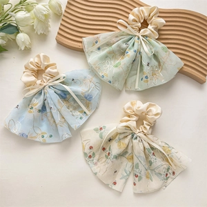 Détail de chouchous à fleurs surdimensionnés avec tulle transparent et broderies dorées