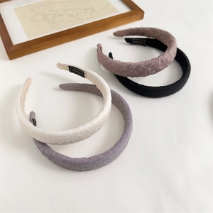 Detail view of handmade pleated sponge headbands in beige, purple, pink, and black