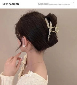 Detail showing elegant wheat stalk hair claw clip with rhinestones in golden alloy finish