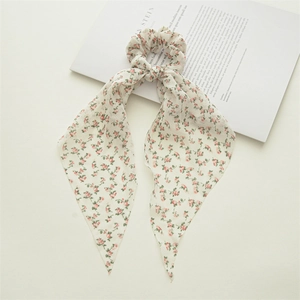 Detail of floral chiffon hair scrunchie with long ribbons on a white background