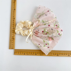 Chouchou à nœud rose avec motif floral et broderie, référence de taille sur blanc