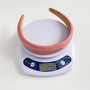Serre-tête rembourré en cuir PU rose mat pesant 29,6g sur une balance numérique