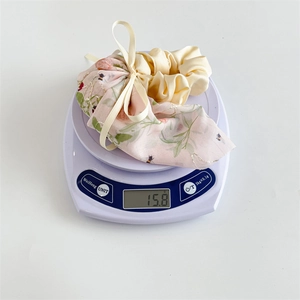 Set de chouchous à fleurs avec nœud blanc pesant 15,8 g sur une balance numérique