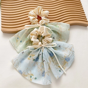 Détails de chouchous à fleurs bleu clair et vert avec rubans et nœuds élégants