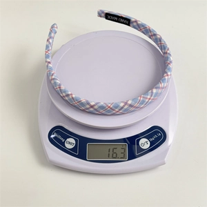 Blue and white plaid sponge headband for women weighing 16.3g on a scale