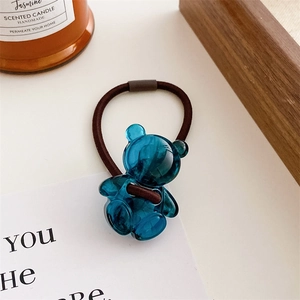 Close-up of a blue translucent resin bear charm on a durable brown elastic hair tie