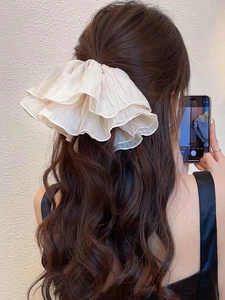 Detail of oversized cream pleated organza scrunchie on a half-up hairstyle