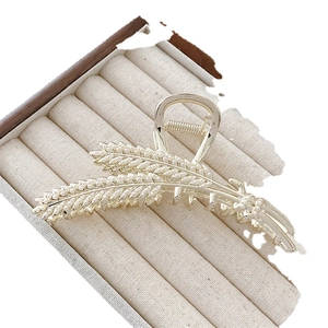 Elegant gold wheat ear hair claw clip with faux pearls for women on jewelry tray