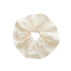 Elegant cream satin oversized scrunchie with ruffled pleats and silky texture for hair