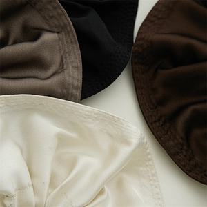 Detailed view of large satin scrunchies with smooth texture and fine stitching in earth tones