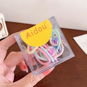 Gros plan d'élastiques à cheveux macaron avec perles mauves en boîte transparente