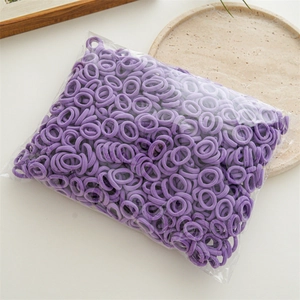 Bulk pack of purple elastic hair ties in a transparent bag on a minimalist stone display