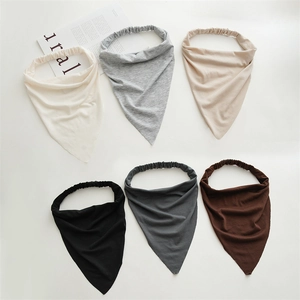 Detail of six assorted cotton triangle bandanas with elastic bands on flat surface