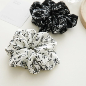 Detail von schwarz-weißen Oversize-Scrunchies mit minimalistischen Blattmuster-Drucken