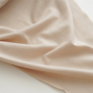 Close-up of lightweight beige cotton knit fabric texture with soft drapery for headbands