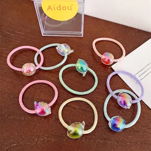 Détail d'élastiques à cheveux macaron colorés avec perles laser irisées sur bois