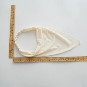 Flat lay measurement of a cream cotton boho headscarf with elastic strap and rulers