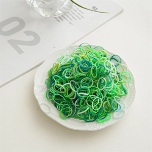 Detailed view of elastic hair bands in green and white colors on a white ceramic plate