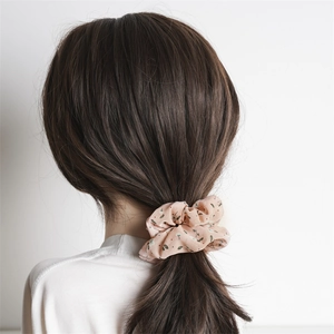 Detailed back view of pink floral chiffon scrunchie on a low ponytail hair style