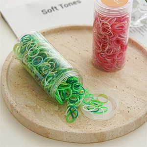 Detailed view of colorful elastic hair bands in clear jars on a stylish stone tray