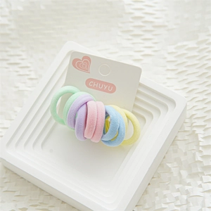 Detailopname van pastelkleurige elastische haarbandjes op een witte displaykaart