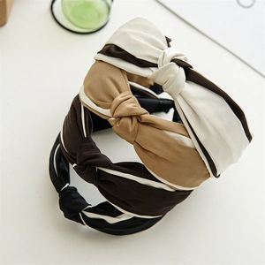 Detail of satin knotted headbands in beige, khaki and coffee with contrast piping