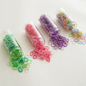 Detail view of colorful elastic hair bands packed in transparent plastic cylinder tubes