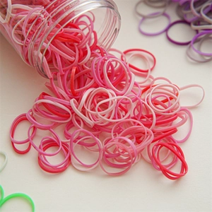 Macro shot of colorful high elasticity hair bands spilling from a clear plastic storage jar