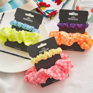 Close-up of bright fabric scrunchies in plaid and solid patterns on display cards