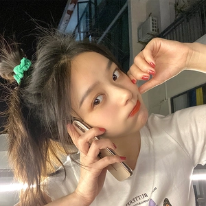 Close-up of bright green satin scrunchie worn on a model hair with rich folds