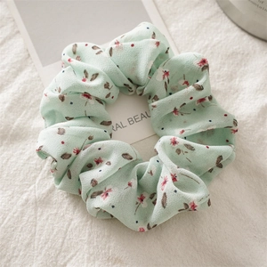 Detail shot of light green floral chiffon scrunchie with soft ruffled texture